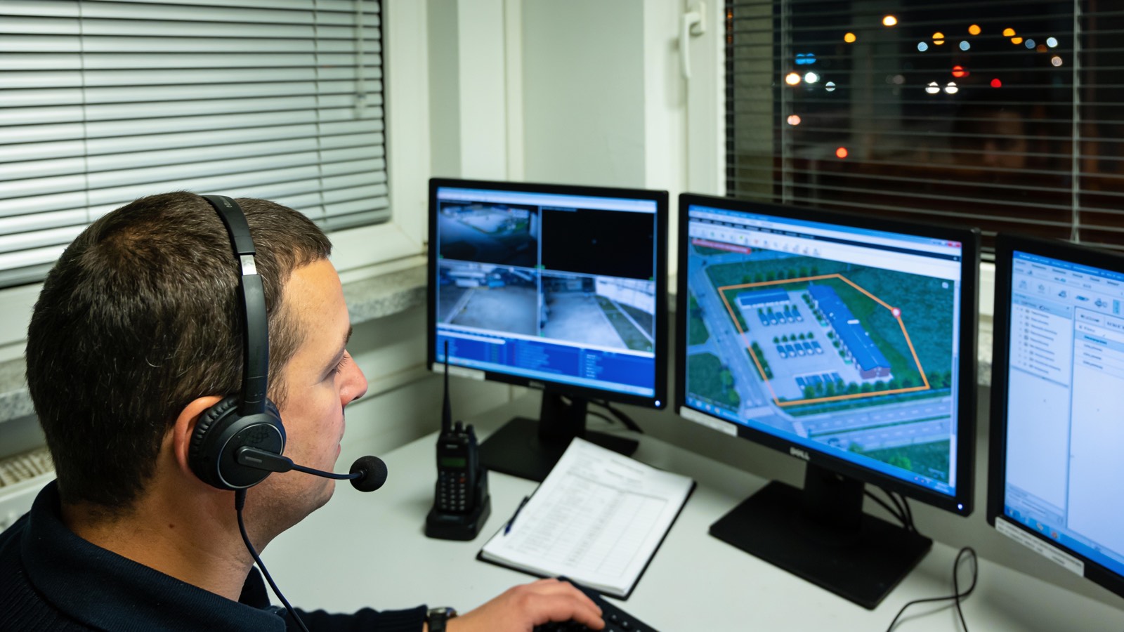 Operator in einer Leitstelle vor Monitoren mit Lagekarte