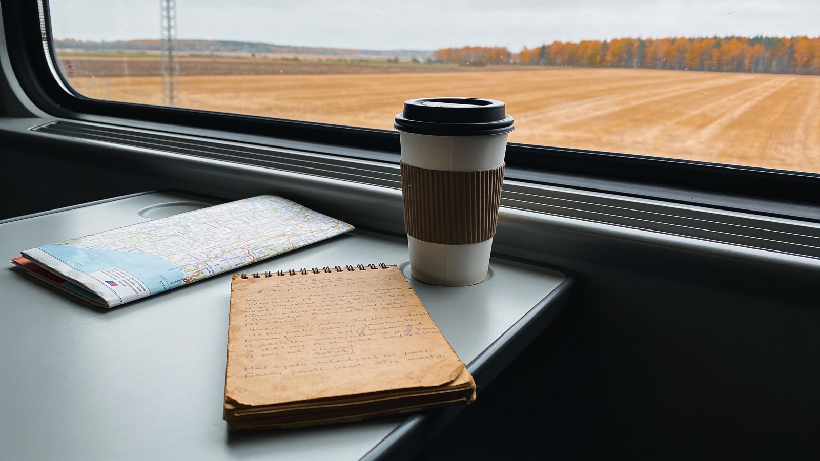 Notizbuch und Karte am Zugfenster